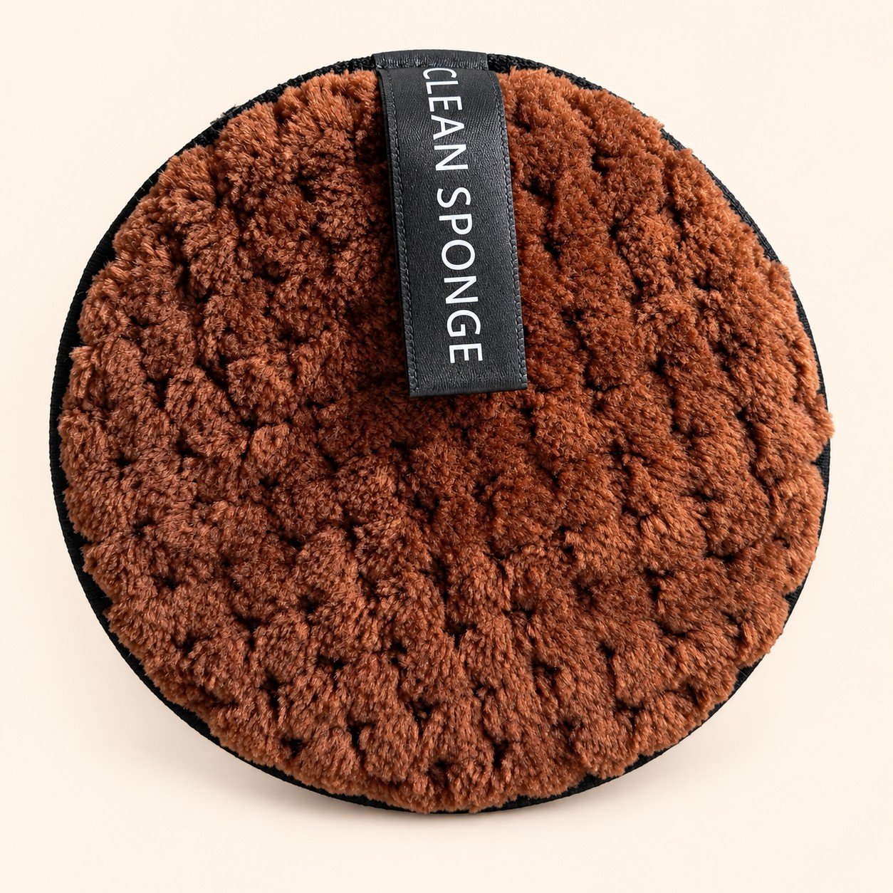 Round Brown Textured Cleaning Sponge — actual item with edited cream background